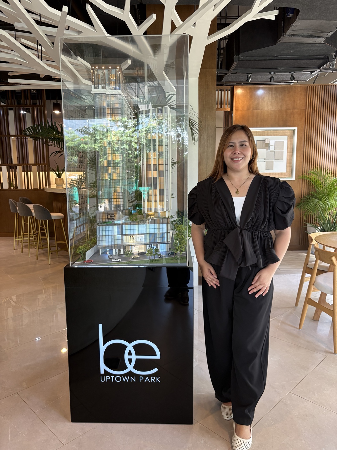 Nessa beside the BE Uptown Park scale model at the showroom